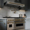 Autograph Edition 48 In. 6.0 Cu. Ft. Legacy Dual Fuel Range With 7 Burner Gas Cooktop And 2 Electric Ovens In Stainless Steel And Champagne Bronze Accents
